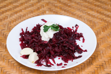 Obraz na płótnie Canvas Grated beets with garlic in a plate