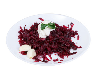 Grated beets with garlic in a plate close-up
