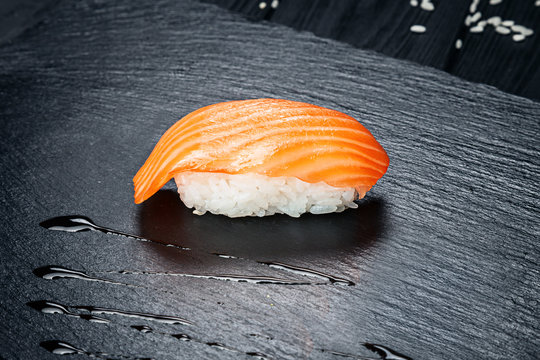 Close up view on sushi nigiri with salmon on dark stone background. Fresh Japanese cuisine. asian food. Sushi image for menu.