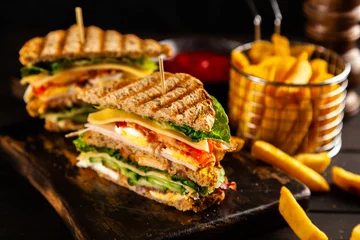 Fotobehang Lange clubsandwich en frietjes © George Dolgikh