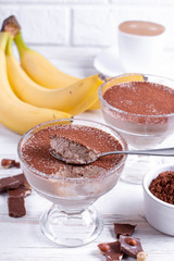 Coffee and chocolate dessert in a glass jar on the wooden table