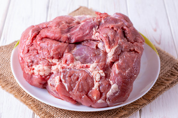 A piece of raw meat on a cutting board on a table