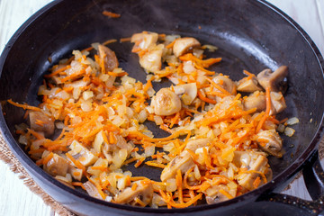 Carrots, onions and mushrooms stewed in a pan