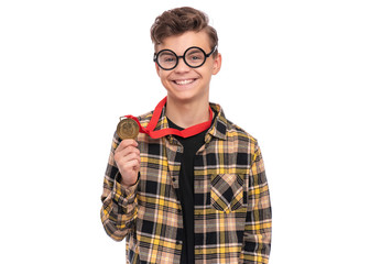 Happy winner. Portrait of Handsome Teen Boy Student in funny eye Glasses holding gold Medal. Child in plaid shirt celebrating his success, isolated on white background. Back to School concept.