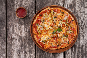 Seafood pizza with sauce on vintage rustic wooden background