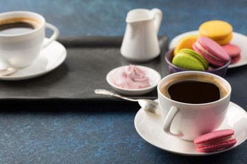 Two cups of coffee and sweets on table