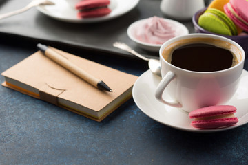Cup of coffee and sweets on table