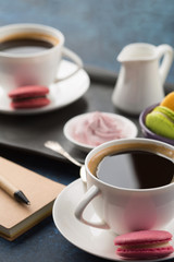 Two cups of coffee and sweets on table