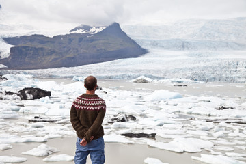 Adventurous man in traditional sweater look on the lake in Iceland
