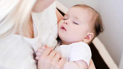 Obraz na płótnie Canvas Sleeping baby lying on mother hands closeup. Motherhood. Maternity.