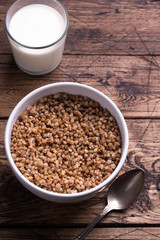 Buckwheat porridge with milk on a wooden table