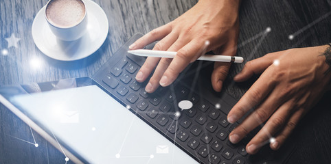 Blogger using mobile touch pad for work at social network message.Closeup view of male hands using stylus pen for working on electronic tablet device