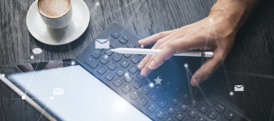 Blogger using mobile touch pad for work at social network message.Closeup view of male hands using stylus pen for working on electronic tablet device