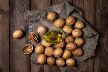 Walnuts on natural wooden background with walnut oil. rustic style.