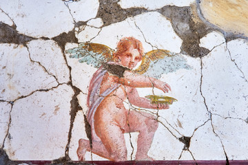Fresco winged cupid in a Domus of the ancient Pompeii