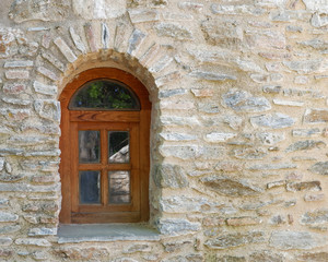 arched wooden window on old stonewall, space for text