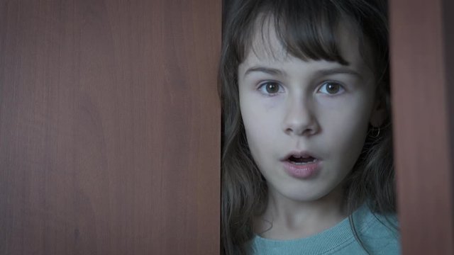 Surprised child peeps into the room.