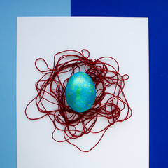 Festive egg. Happy Easter. The decor of the thread. Blue shades.