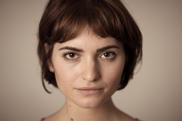 Natural portrait of young attractive woman looking and posing with neutral face expression