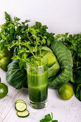 Detox cucumber smoothie in glass at wooden white background.