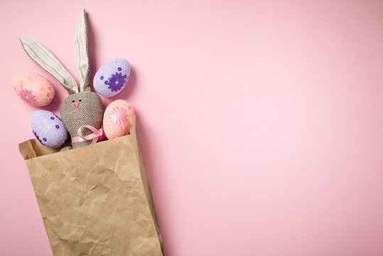 Easter Bunny in a paper bag on a beautiful, pink background. 2019. Easter eggs. Space for text. Happy easter.
