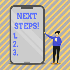 Writing note showing Next Steps. Business concept for something you do after you have finished something else Man Presenting Huge Smartphone while Holding Another Mobile