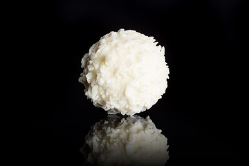 One whole fresh bio coconut ball isolated on black glass