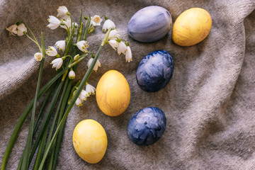 Obraz na płótnie Canvas Spring flowers are snowdrops and Easter eggs painted in yellow and blue colors on a soft canvas. Festive set. Greeting card.