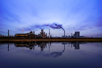 Fototapeta premium Reflection of refineries and its chimney during the on blue sunset hour moment at Rotterdam, Netherlands