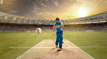 Young sportsman strikes the ball while batting in the cricket field	