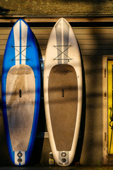 Norfolk, Connecticut, USA A pair of windsurfing boards drying by the side of a house with a yellow door.