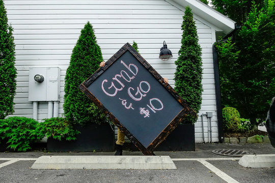 Falls Village, Connecticut USA A Grab & Go Menu Sign Being Transported Through The Parking Lot Of A Restaurant.