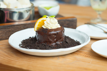 Chocolate lava cake with orange slice and whipping cream