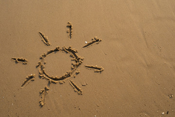 Vacation on the sand beach concept. The Sun symbol, sunshine drawing into the sand on the beach at Rayong, Thailand
