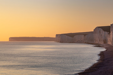 Looking out over the Sussex coast at sunset, with the Seven Sisters cliffs and a calm sea