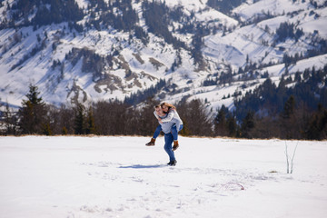 People having fun and running in mountains on the background of high snow-capped peaks