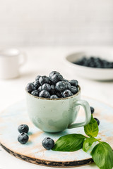 Fototapeta na wymiar Fresh blueberries in a cup on white background