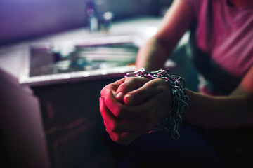 Drugs tie hands. Choose life not drugs. Close-up of woman tied hands with metallic chain in night club's toilet. Obsession and pain. To find way out