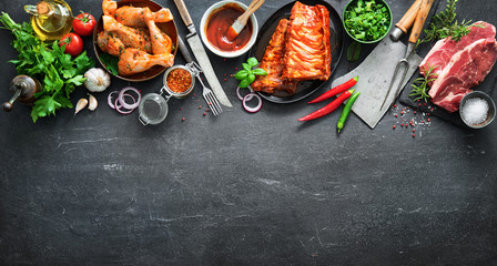 Various kinds of grill and bbq meats with vintage kitchen and butcher utensils