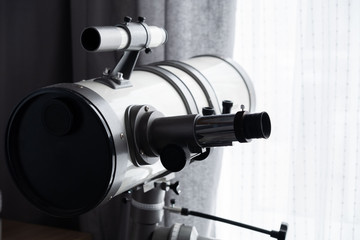 Modern telescope directed to the window