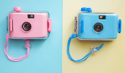 Pastel film camera on color paper background 