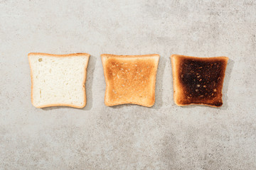 Top view of bread toasts on grey textured surface