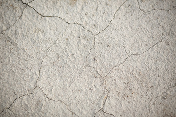 the texture of the earth in cracks. A textural, close-up image of sandy desert ground cracked by the heat and lack of water.