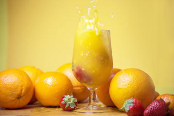 glass of fresh orange juice with fresh fruits on wooden table