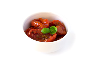 Sun-dried tomatoes in olive oil a white bowl with basil isalated on white background
