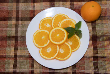 Sliced oranges on a white plate. Fruits are chopped. Orange