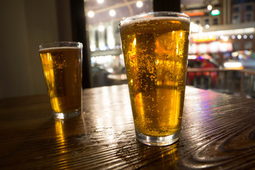 two glasses of lager beer on wooden table