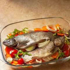 Fresh sea fish with spices and vegetable ingredients on wooden table, cooking concept.
