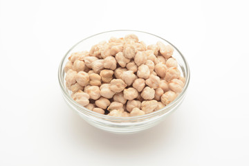 Garbanzos gordos en un cuenco de cristal sobre fondo blanco