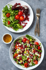 Healthy salad with tomatoes, feta, pomegranate seeds and leek.